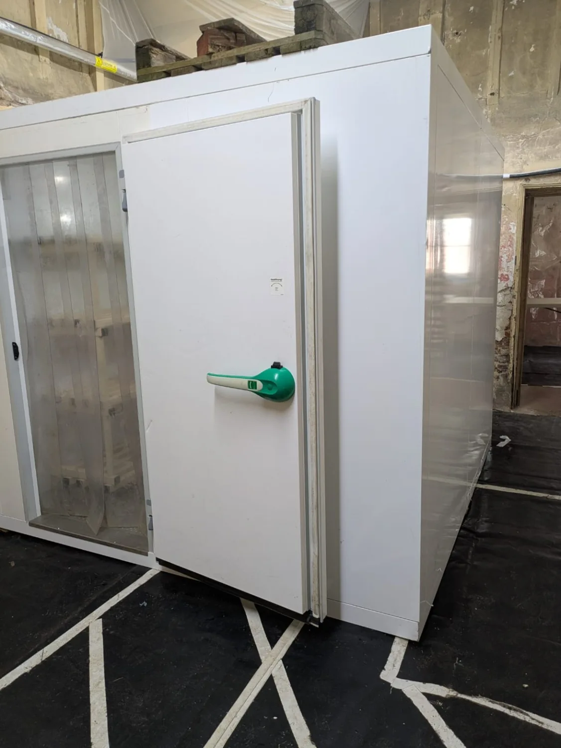 Indoor modular cold room with a wide doorway and strip curtains