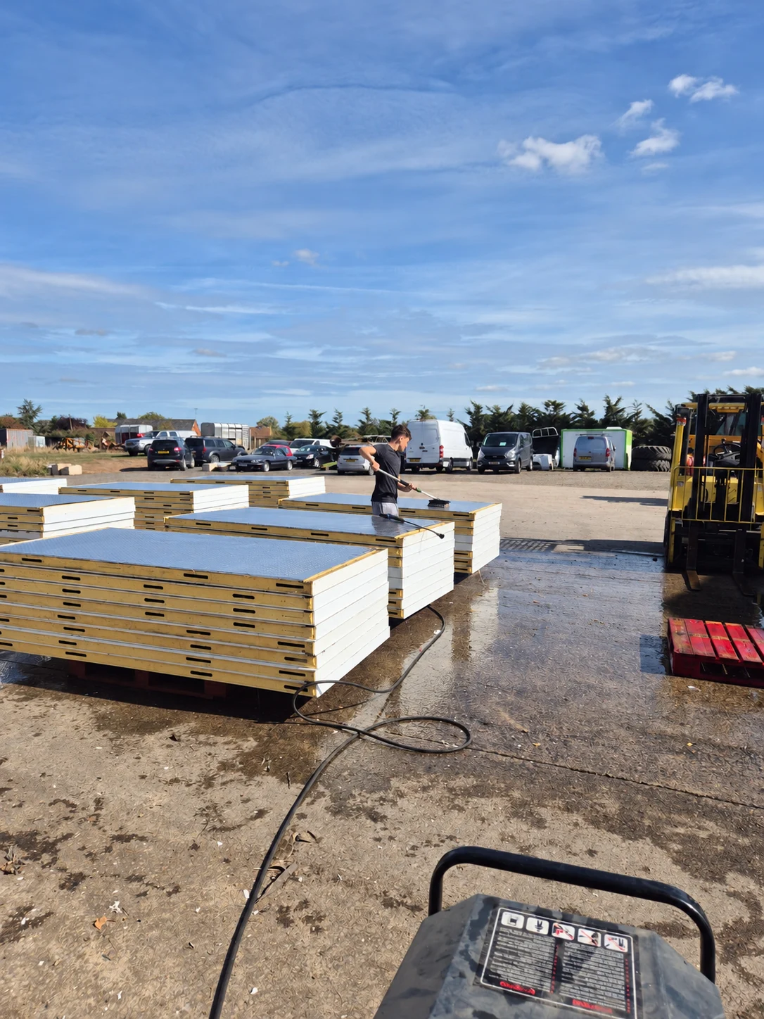 VCS team washing stacked cold room panels outside in the yard ahead of the winter season
